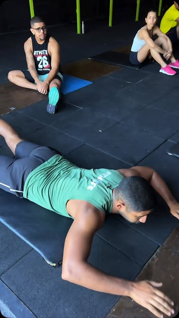 Turma realizando exercícios e alongamentos no solo da Arena